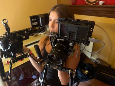 Woman operating a professional video camera indoors.