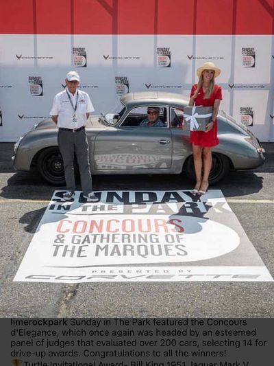 Man and woman standing outside a vintage Porsche with man sitting inside