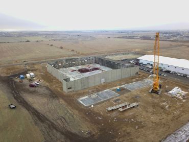 Construction site with crane and concrete structure.
