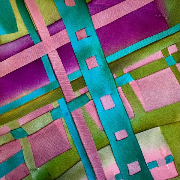 Colorful geometric fabric with intersecting stripes and squares.