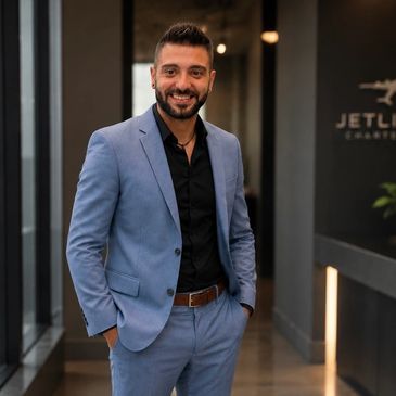 Man smiling confidently in a blue suit.