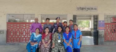 Group photo of people posing outside a building labeled 'Waiting Hall'.
