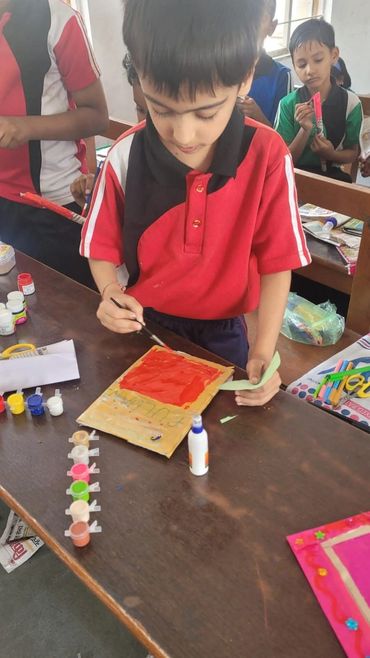 Boy painting a craft project in a classroom.