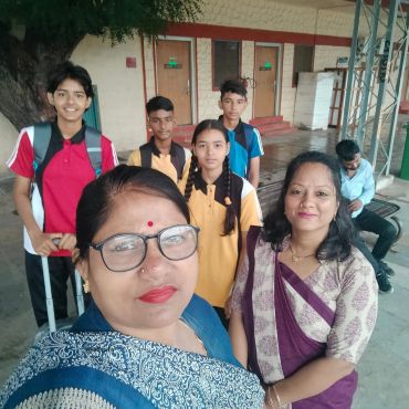 Group of students and teachers smiling at the camera.