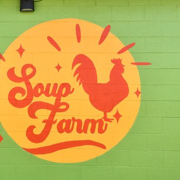 Bright green painted brick background with orange and yellow soup farm lettering in circles