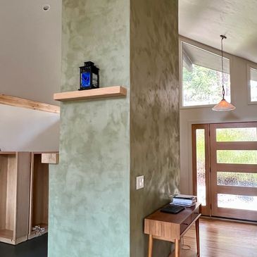 Finished green plaster fireplace in modern wood floor home