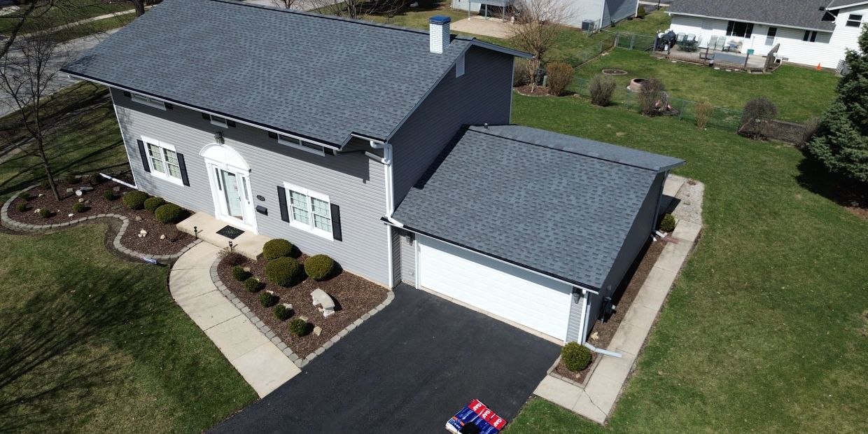 A gray house with a blue-gray roof and a two-car garage.