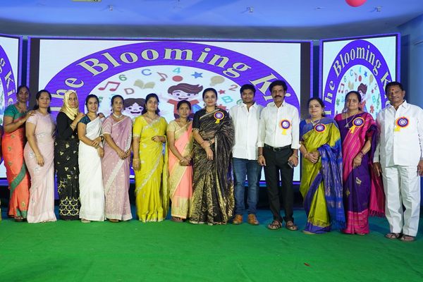 Group of people posing at The Blooming Academy event stage.