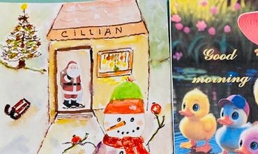 Festive holiday cards featuring a snowman scene and duck family illustration.