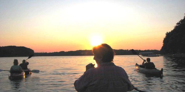 Northern Paddle and Trail club members kayaking into the sunset.