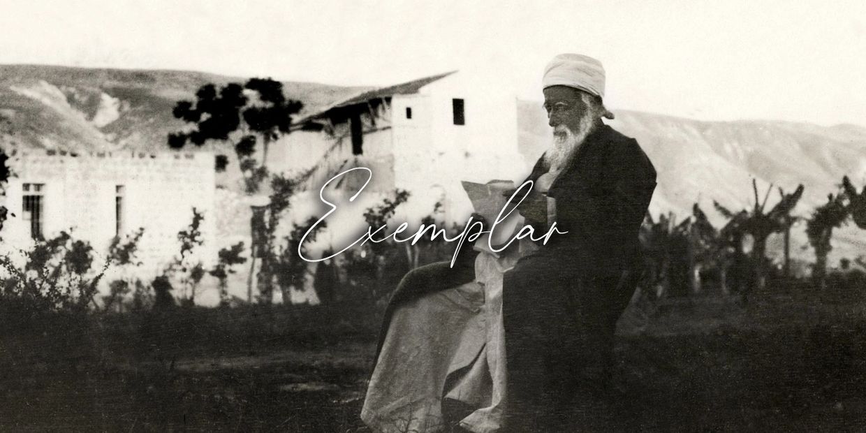 Elderly man reading outdoors in a rustic setting.