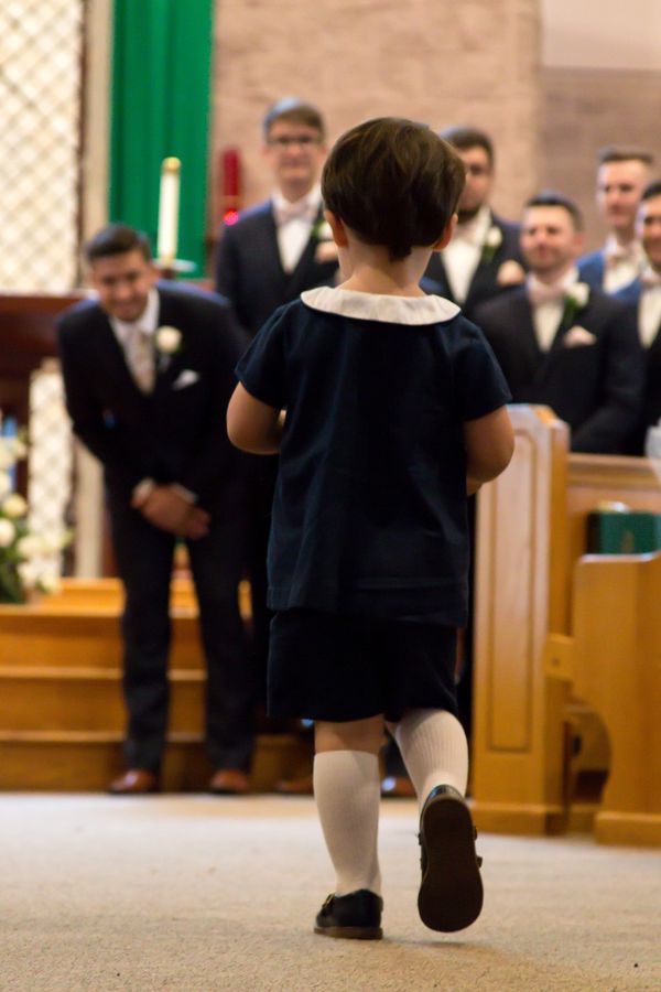 A young boy walking down the aisle at a wedding ceremony.