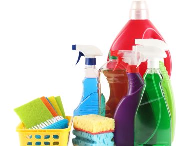 Various colorful cleaning supplies and sponges against white background.