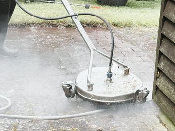 A surface cleaner attachment pressure washing an outdoor area.