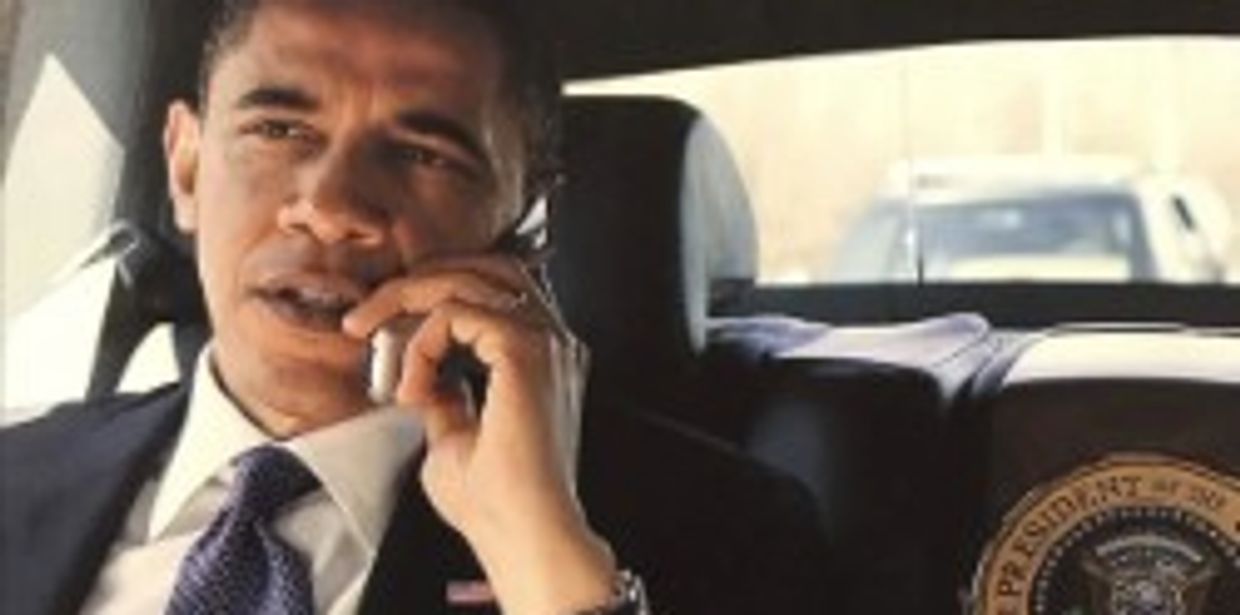 Man in suit talking on phone in car