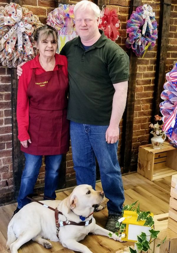  Shop owners Chris and Carol along with guide dog Fiona.