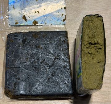 Two blocks of concentrated herbal or plant material, one dark and one greenish.