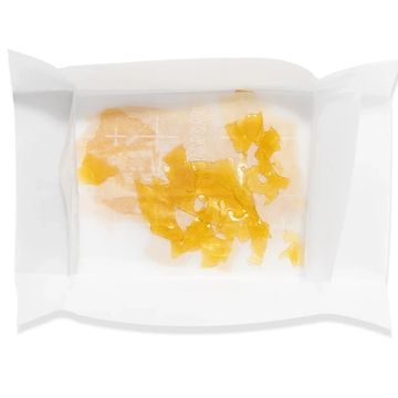 Yellow crystalline substance on white parchment paper.