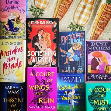 A colorful array of romantic and fantasy novels displayed on a carrot-themed cloth.