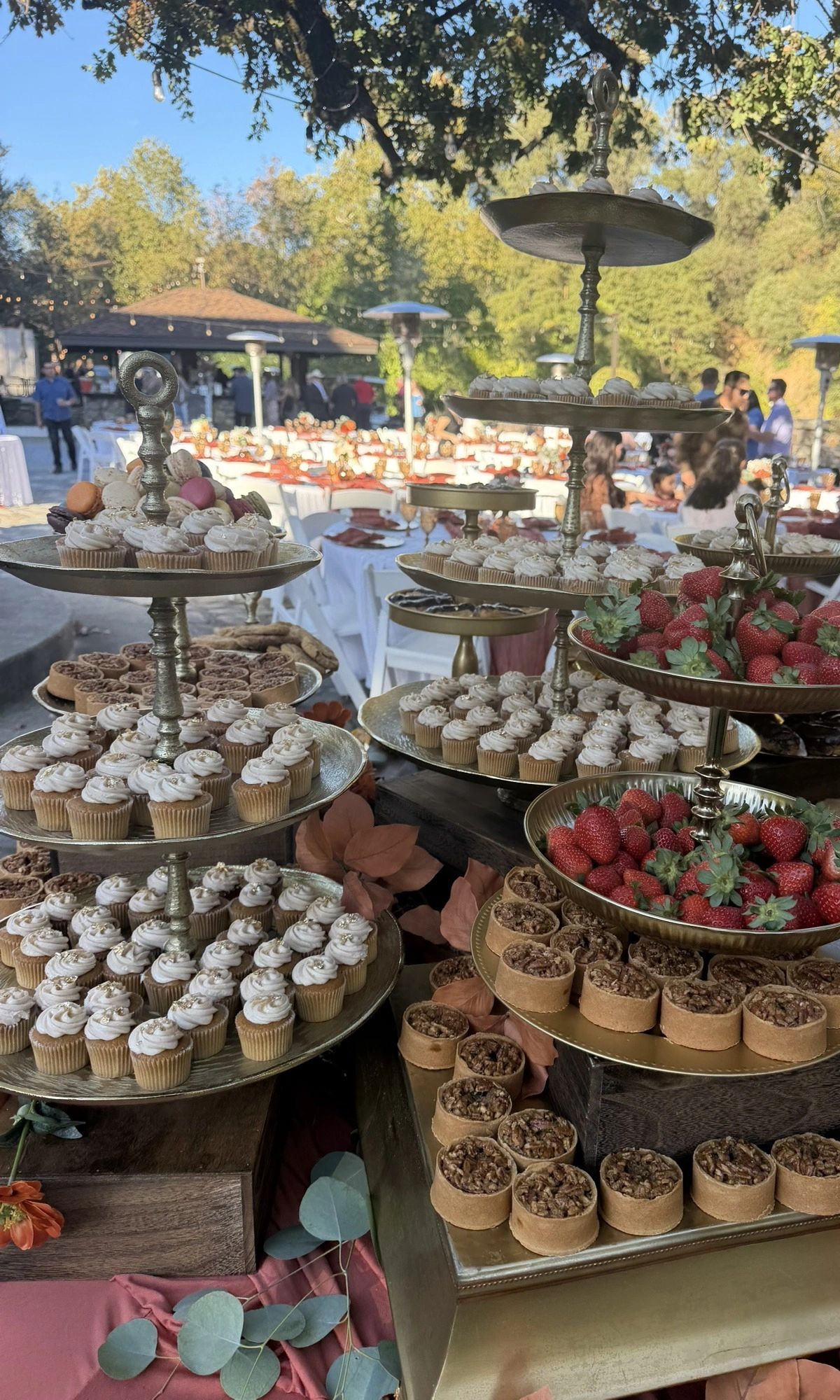 Blingmakers dessert table with mini cupcakes and tarts on gold tiered risers