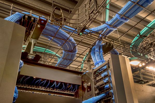 Close-up view of meticulously organized blue and green cables running through a data center.