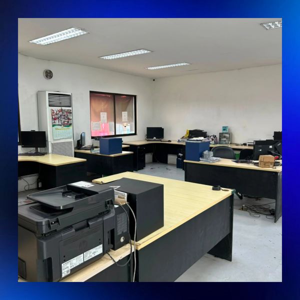 Empty office with desks, computers, and a printer.