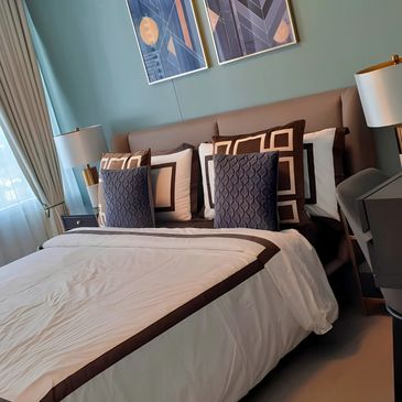 Modern bedroom with a neatly made bed and decorative pillows.