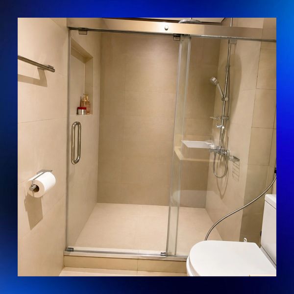 Modern beige bathroom with glass shower and toilet.