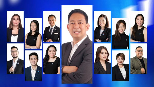 Professional group portrait of diverse businesspeople against a blue background.