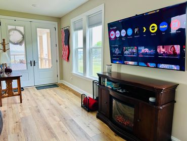 View of large smart TV over an electric fireplace with water views