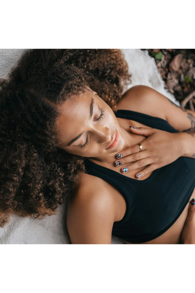 Woman laying down and relaxing with hand on heart