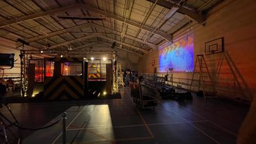 Indoor setup with lighting and projection in a gymnasium.