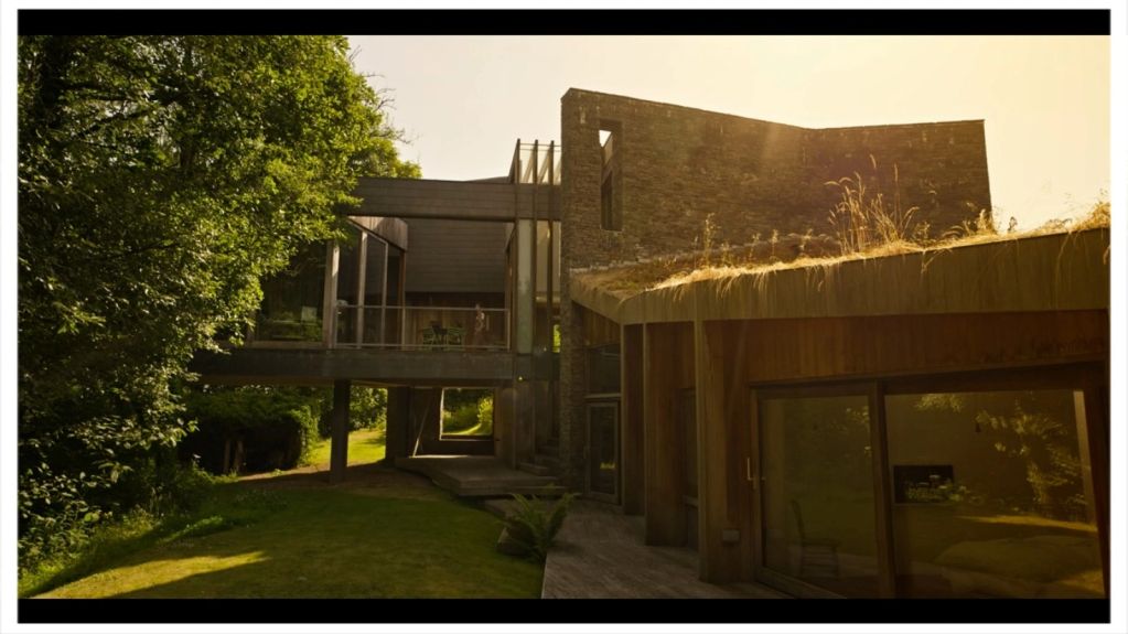 Modern house with greenery and sunlight.