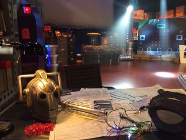 A futuristic workspace with a robot head and control panels.