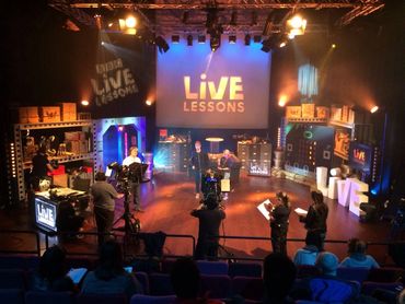 A live lesson recording in a studio with cameras and crew.