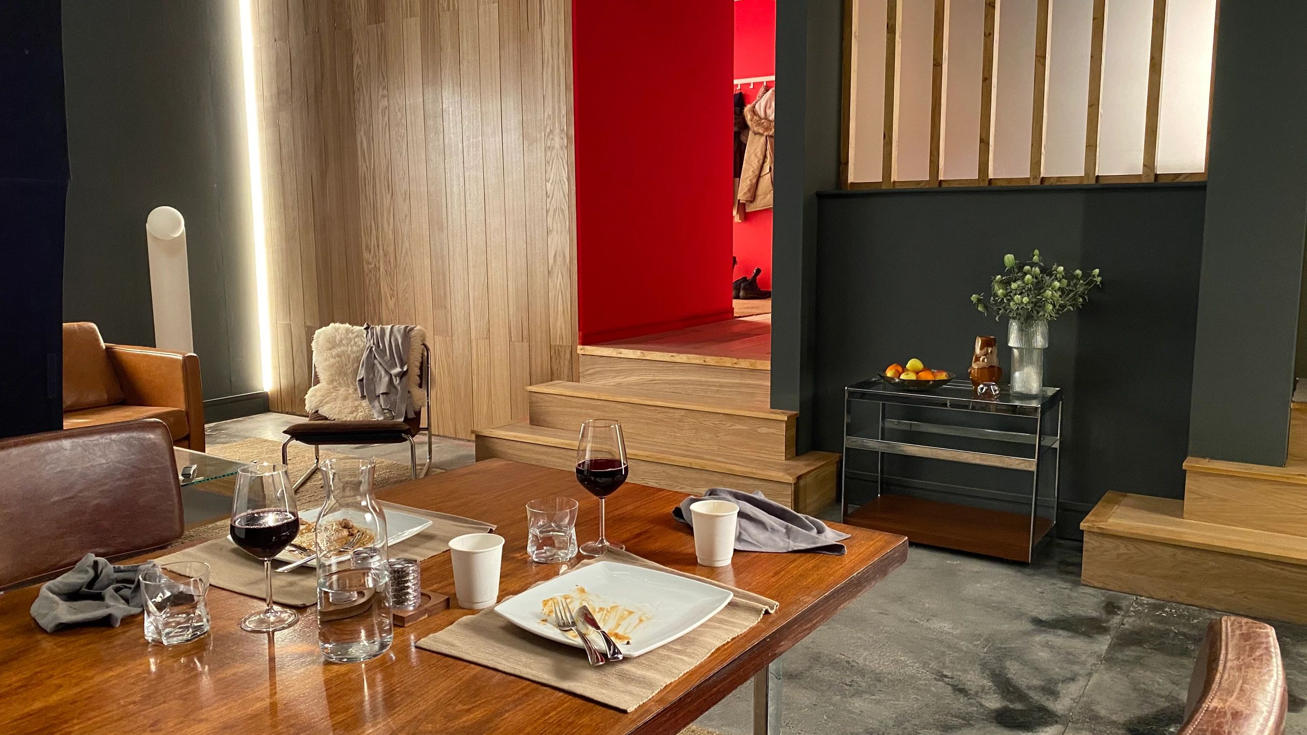 Modern dining area with wooden furniture and dim lighting.