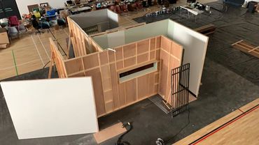 Indoor set construction with wooden walls and props.