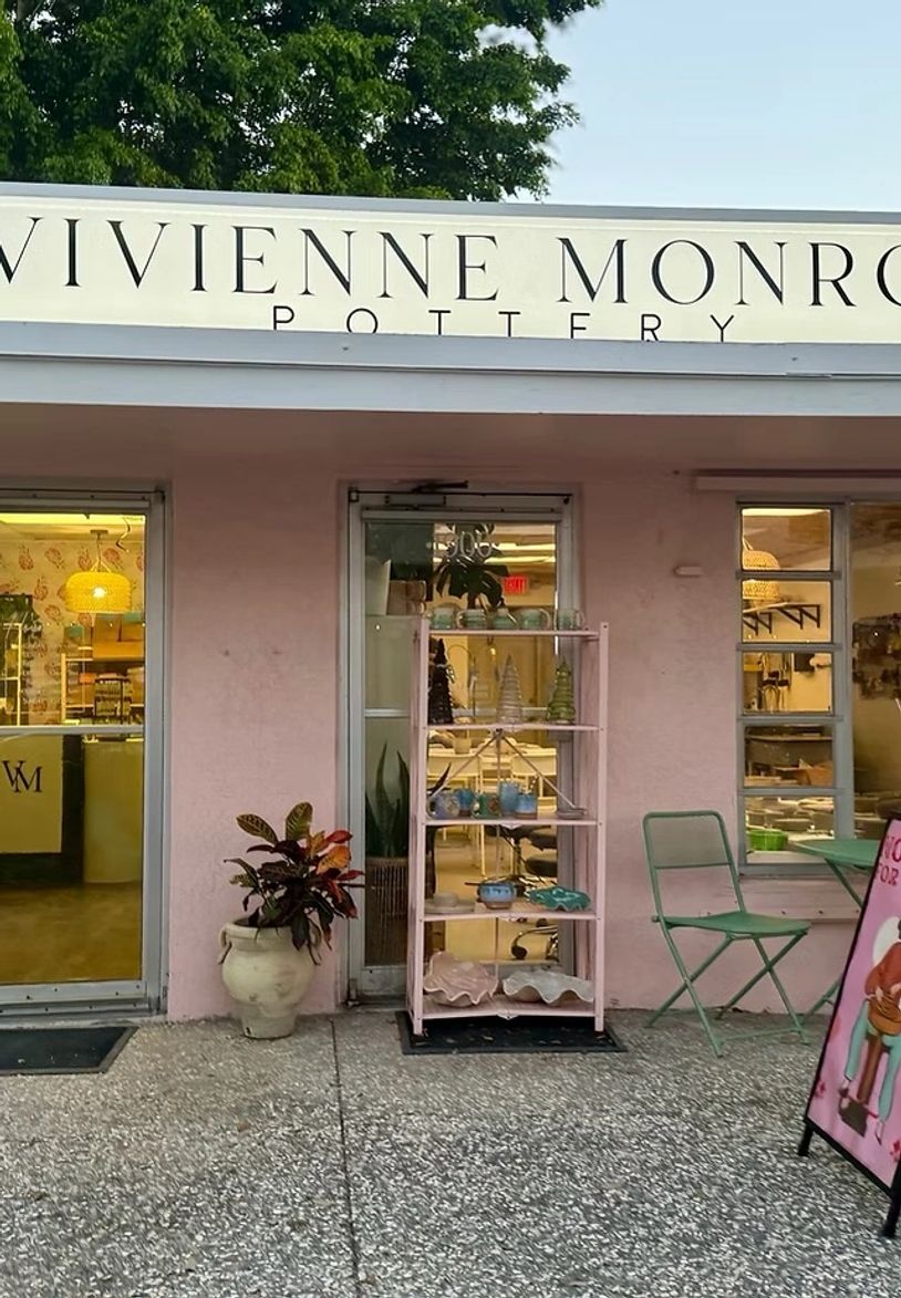 Exterior of Vivienne Monroe Pottery with displayed ceramics and outdoor seating.