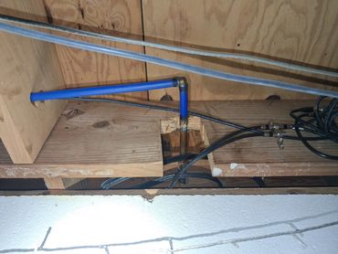 A floor joist severely notched for plumbing lines, compromising structural integrity in Linden.