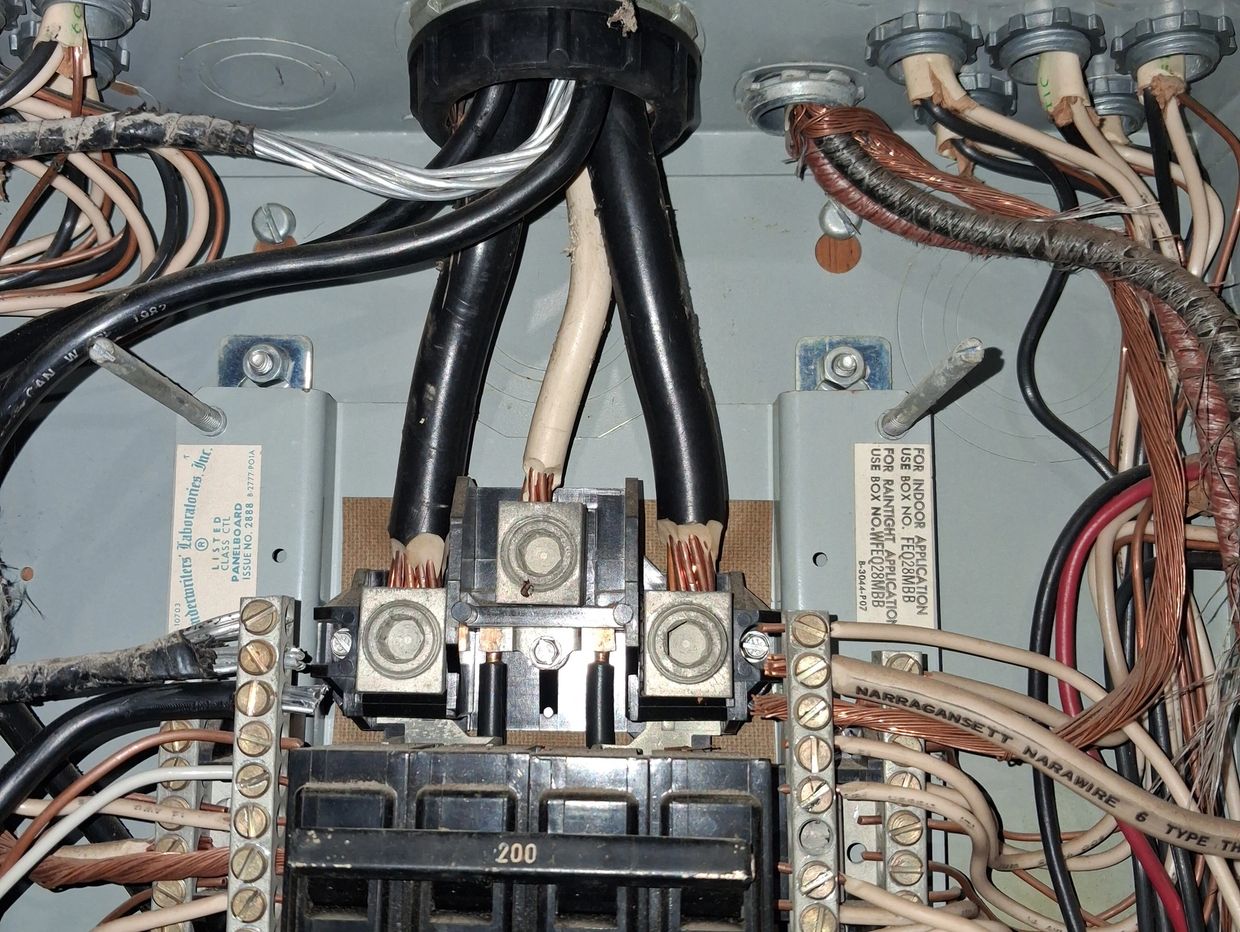 Licensed home inspector checking a 200-amp electrical panel for safety hazards.