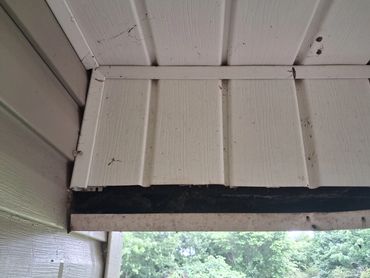 Rotten wood eave header exposed by a missing vinyl soffit panel during an Elkmont AL home inspection