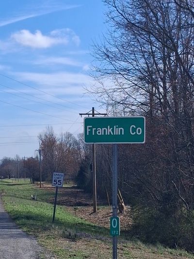 Green Franklin Co sign on John Hunter Highway under a clear blue sky.