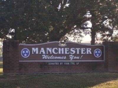 Manchester welcome sign with greenery.