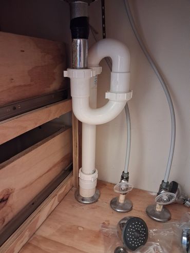 Improper S-trap & taped drain under bathroom sink.