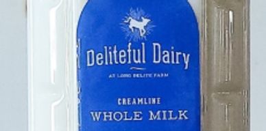 A blue and white milk carton labeled Deliteful Dairy Creamline Whole Milk.