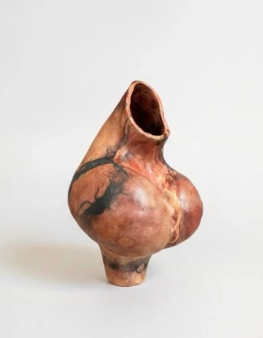 Artistic ceramic vase with organic shape and earthy tones.