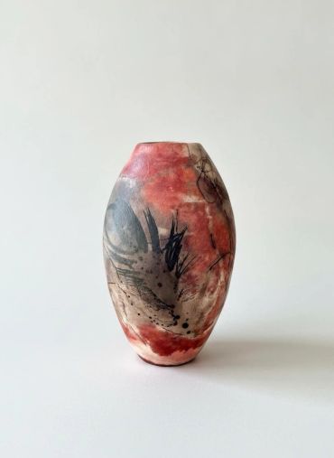 Artistic ceramic vase with red and black patterns.