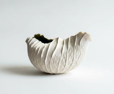 White textured abstract ceramic bowl on a plain background.