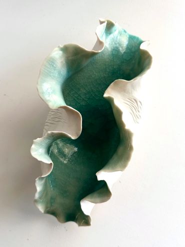 Ruffled ceramic bowl with blue-green glaze.