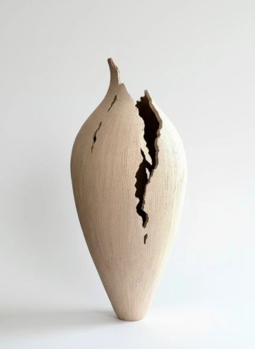 Tall, cracked ceramic vase with a textured surface.